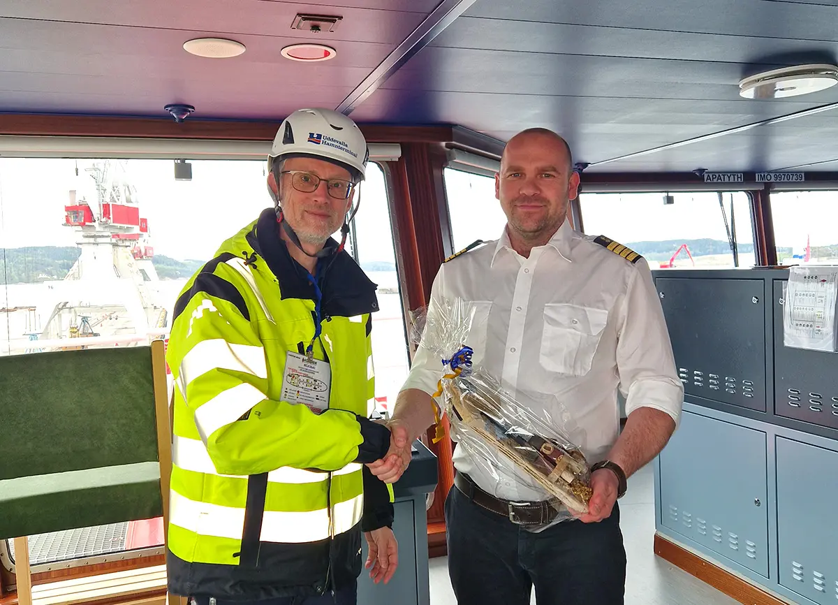 Uddevalla Hamnterminals marknadschef Jacob Engholm överlämnar en gåva till fartyget Apatyths kapten, Lukasz Magierek.